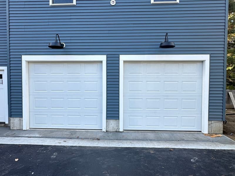 White raised-panel dual doors on blue new construction home alternate angle